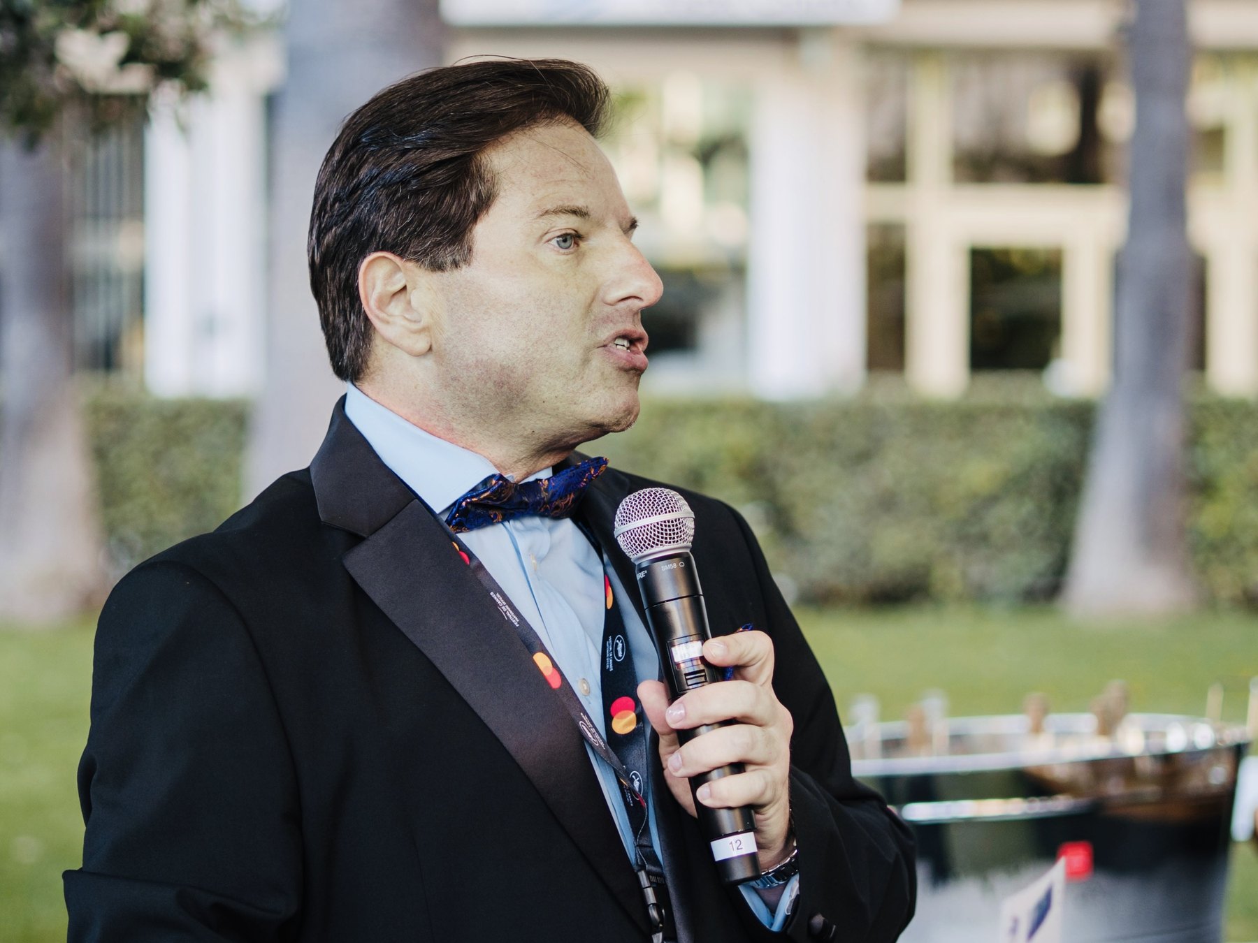 Brian Calfano speaking into a microphone at the Cannes Film Festival