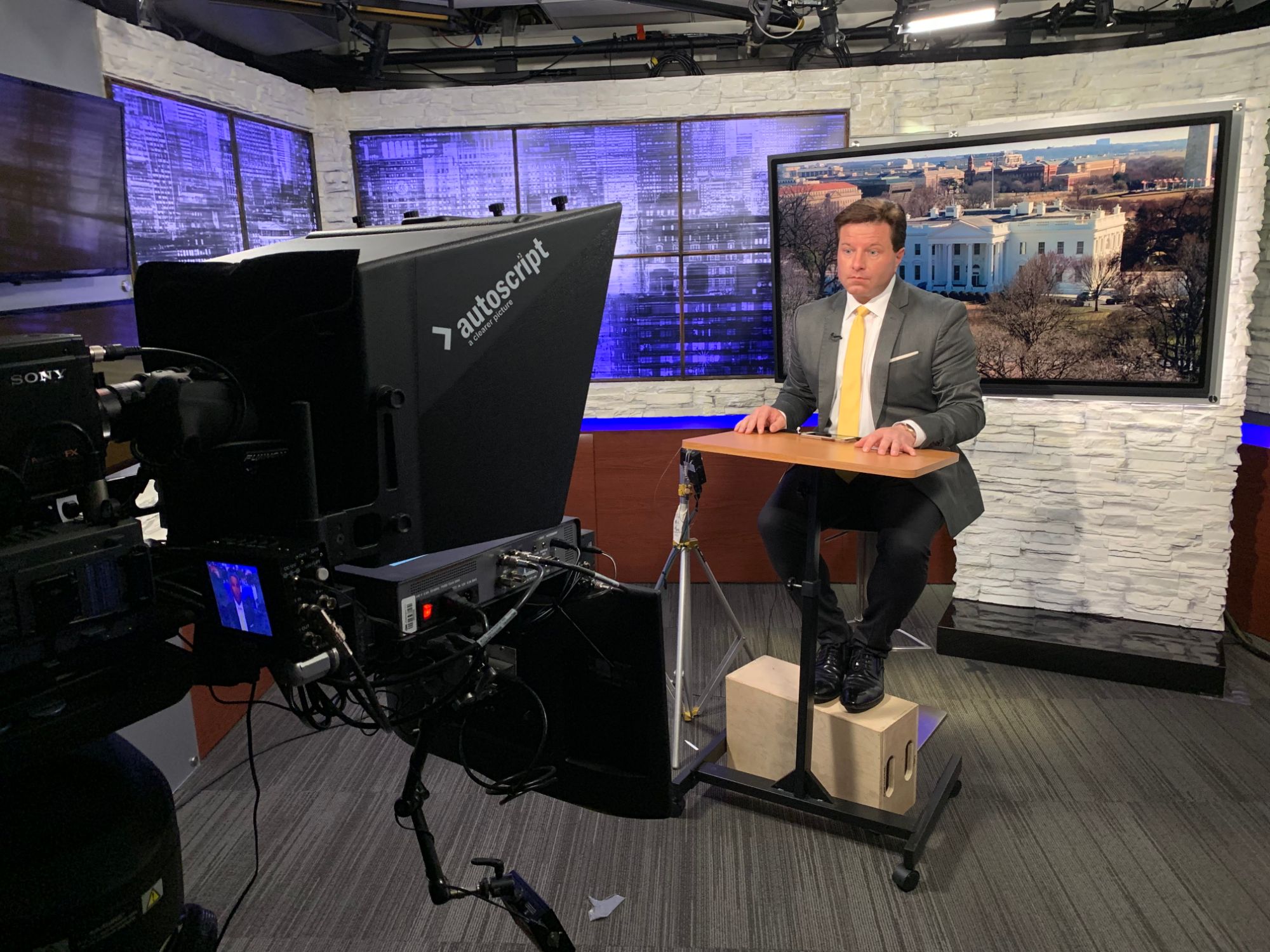 Brian Calfano at the anchor desk with a White House backdrop